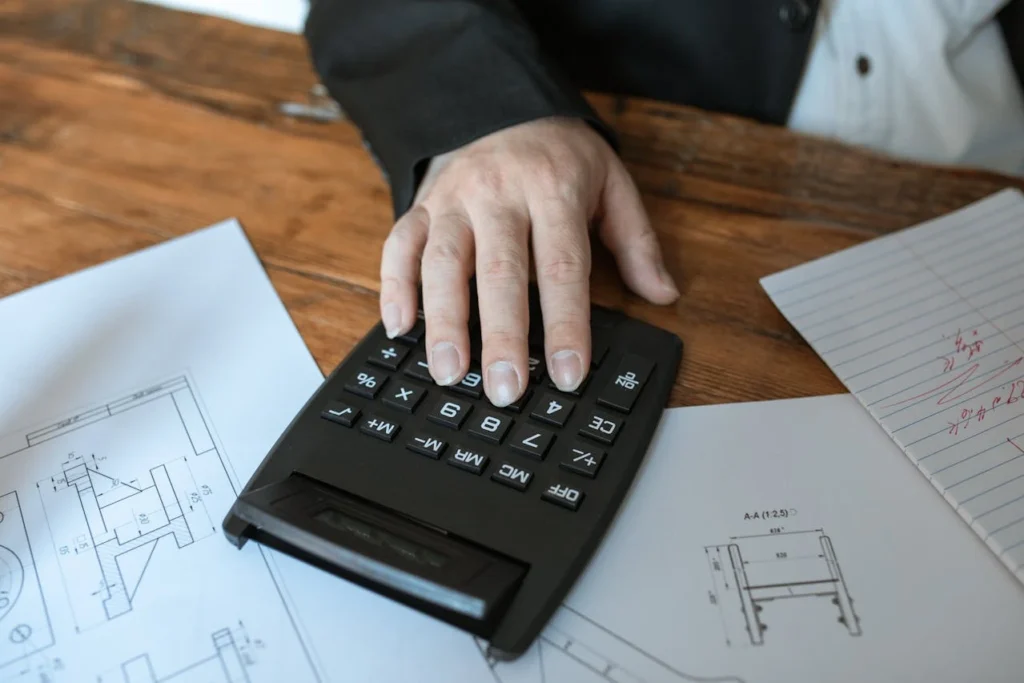 man performing construction budget calculations on calculator
